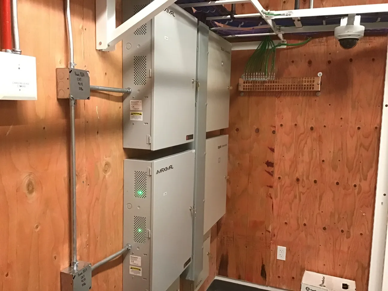Security equipment backboard with power supplies, a ground bar, terminated cable bundles and a dome camera